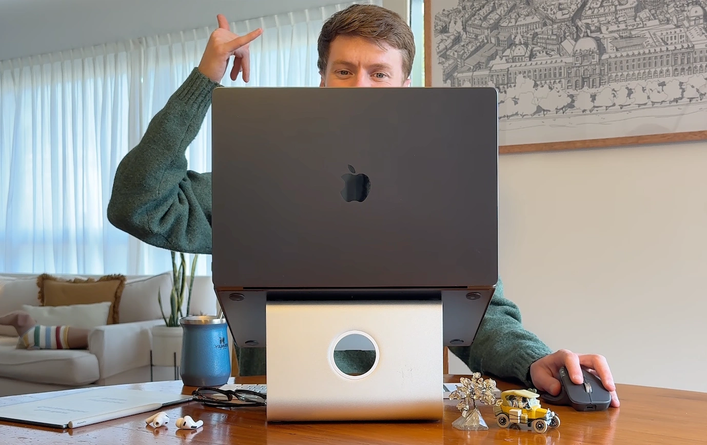 Eliott at his desk, his laptop waiting to be decorated. Drop logos anywhere on the laptop or its stand.